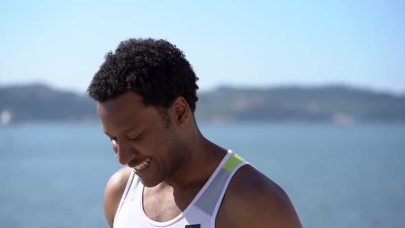 Happy African American Sportsman Jogging at Riverside