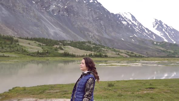 Young Woman on the Background of the Mountains Runs and Dances. Traveler