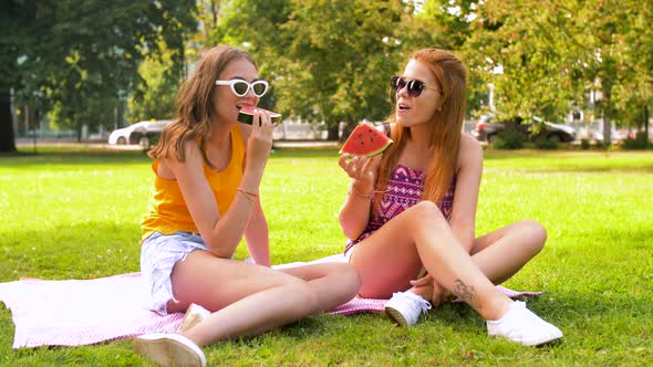 Teenage Girls Eating Watermelon at Picnic in Park