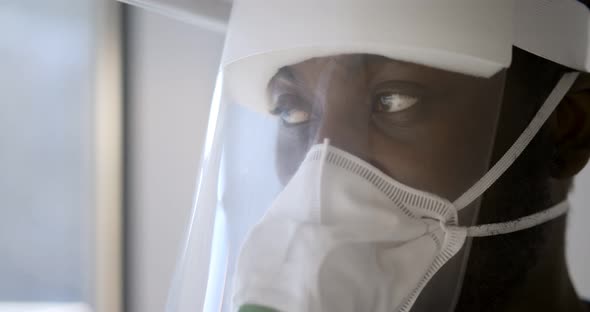 Close Up Portrait of African Doctor Wearing Respiratory Mask and Face Shield in Hospital
