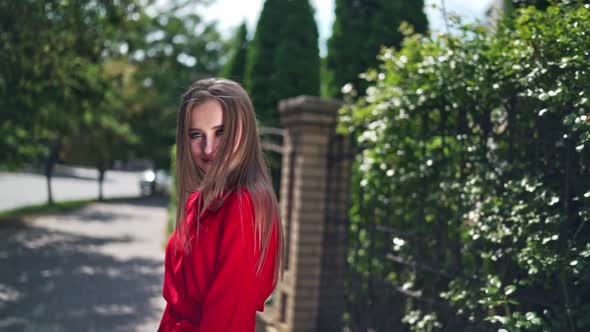 Passionate young girl posing to camera. Beautiful young model in red dress with long hair