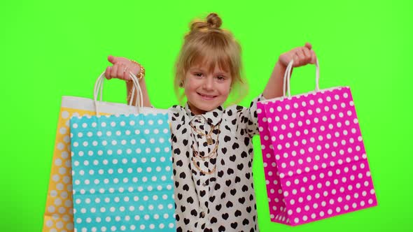 Kid Girl Showing Shopping Bags Advertising Discounts Low Prices Shopping on Black Friday Holidays