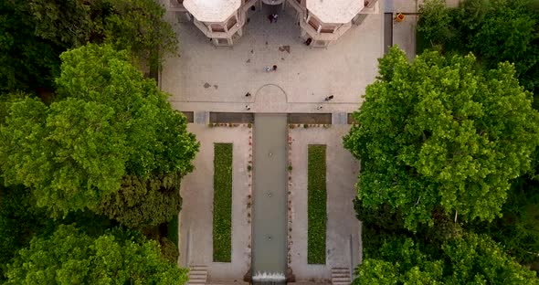 Aerial moving down on a Persian garden with a beautiful historical palace building, green trees and