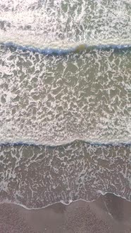 Drone view of the beautiful waves on the sandy beach,