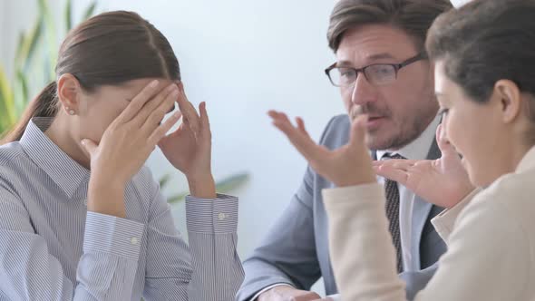 Angry Male and Female Business Person Scolding Female Colleague