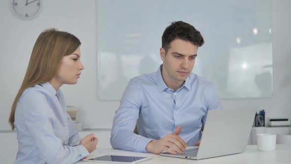 Young Business Colleagues Discussing Project on Laptop Disagree