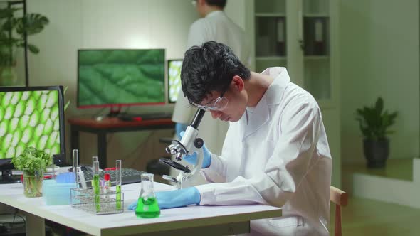 Biochemistry Doctor Examining Chemical Test Using Microscope For Genetic Researcher