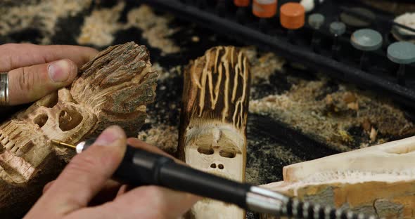 Close up male hands using power wood working tools graver, carving