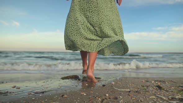 Attractive Slim Legs of a Woman in Slow Motion Walking Barefoot Along the Beach in the Early Morning