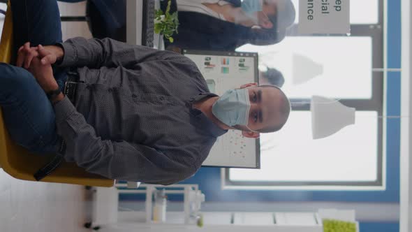 Vertical Video Portrait of Businessman Sitting at Office Desk Wearing Medical Face Mask