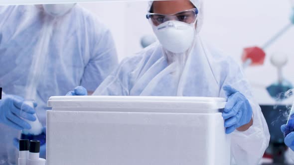 Female Scientist Opening a Refrigerator Box in Modern Science Laboratory alt
