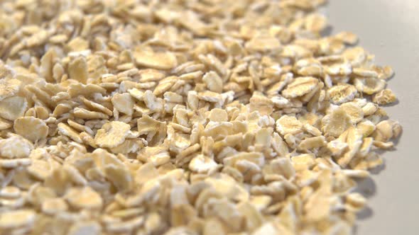 Crushed oatmeal flakes on a paper packaging. Cereal raw breakfast porridge. Organic product