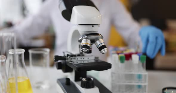 Microscope in the Laboratory with Test Tubes and the Work of Scientist alt