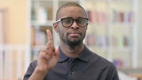 Portrait of Young African Man Saying No with Finger Sign