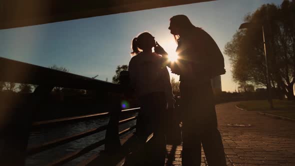 Mother and Daughter Silhouettes Under the Bridge