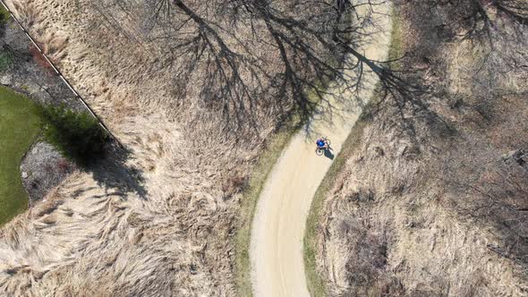 Aerial Top View Cyclist Is Engaged in a Healthy Lifestyle. Bike Ride in the Park. A Quadrocopter