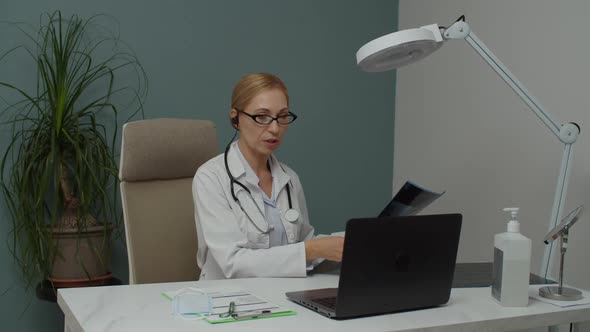 Female Doctor Diagnosing Xray Image Online Via Video Calling Indoors