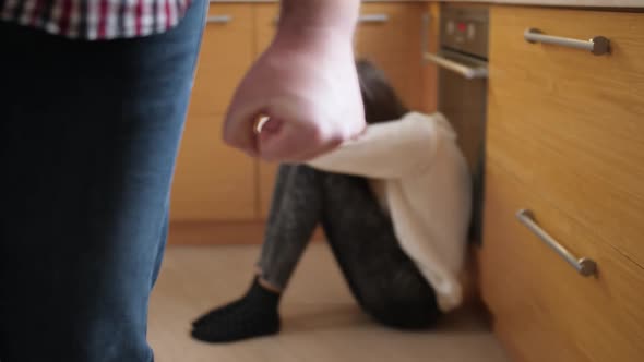 Angry Man Walking Away From Crying Girl Sitting on Floor