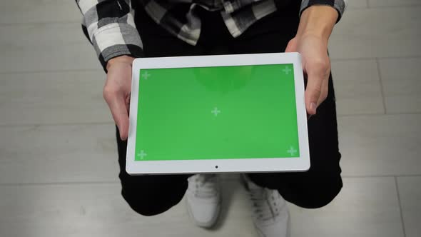 Man Sitting on Chair Looking at Digital Tablet with Green Screen Chroma Key