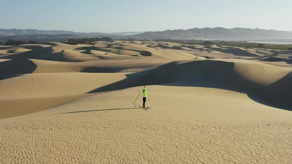 Woman Performing Spiritual Yoga Pose on Top of Sand Dune Desert at Sunrise in VR