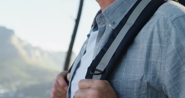 Senior man standing with backpack at countryside 