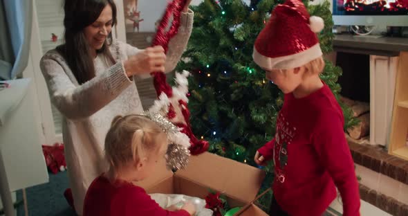 Happy Family Unpacking Christmas Decoration in Preparation for Holidays