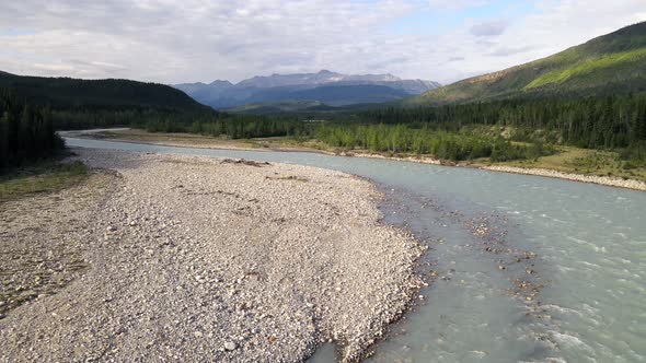 Drone flying backwards revealing the majestic Toad river at sunset in Northern British Columbia, Can