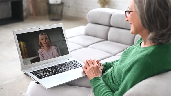 Mature Senior Woman Is Using a Laptop at Home