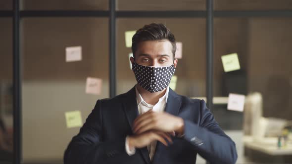 Business Meeting, Young Man in Suit Stands in Conference Room, Man Removes a Cloth Mask, Protect