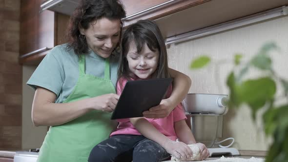 Family with gadget in the kitchen. 