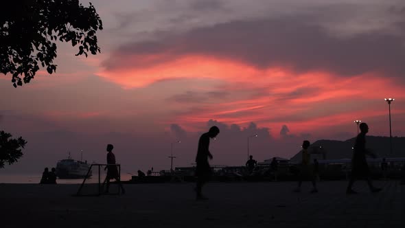 Children Play Soccer on the Pier After Sunset