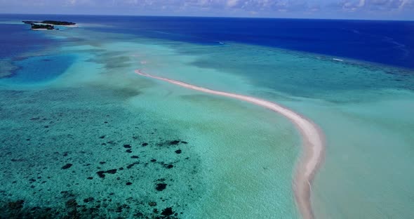 Wide angle above travel shot of a paradise sunny white sand beach and aqua blue ocean background in 