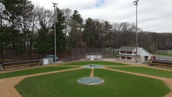 View of empty ball field in residential neighborhood with recently groomed field.