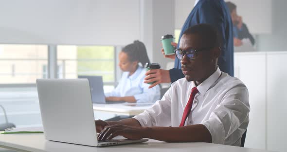 Young African Businessman Concentrate on Working with Laptop at Busy Office