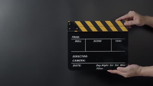 Movie clapperboard footage. Man hand holding film slate and clapping it in studio before shooting