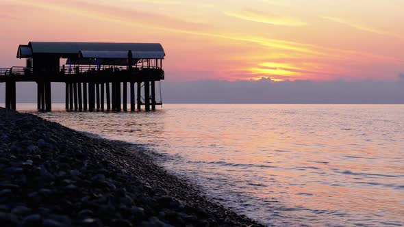 Panorama of the Sunset Over the Sea Next To the Silhouette of the Pier.