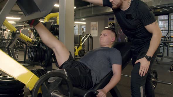 Young Man with Prosthetic Leg Using Leg Press Machine in Gym