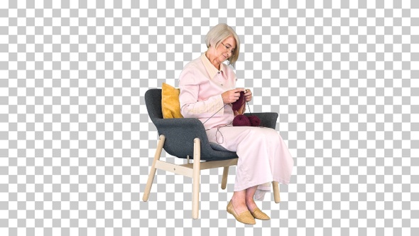 Elderly woman in glasses knits clothes, Alpha Channel