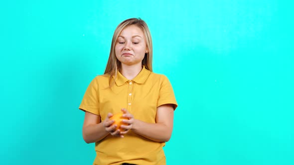 The Young Woman Receives an Orange and Is Happy