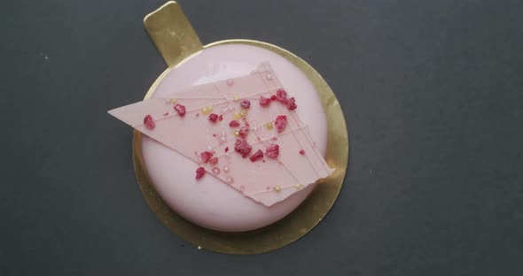 Shot of Tasty Sweet Round Dessert with Pink Cream on Black Background