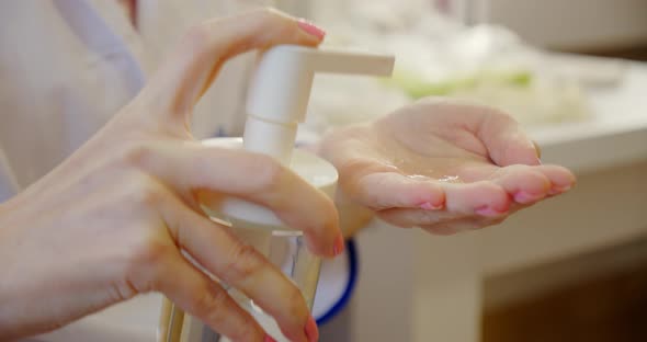 Female Hands Using Antibacterial Hand Sanitizer Pump Dispenser Antiseptic. Close Up