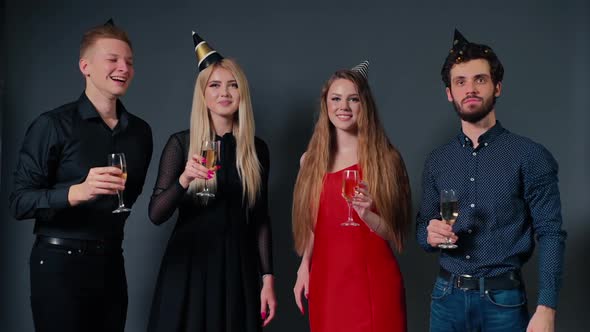 Two Attractive Guys and Two Beautiful Girls Clinking with Champagne Glasses