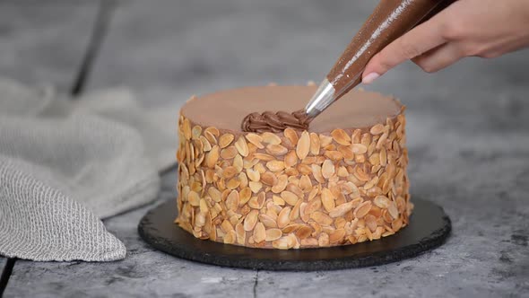 Chef Decorating Chocolate Cake with Cream