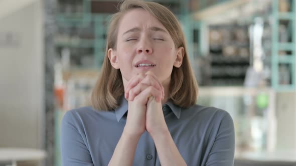 Portrait of Young Woman Praying with Eyes Closed