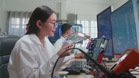 Asian Female Engineer Inspects Printed Circuit Board Motherboard. Scientist Designs Industrial Pcb