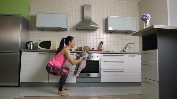 Cheerful Fit Mom Doing Squats with Baby at Home