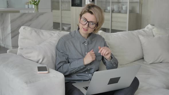 Young Woman in Grey Shirt Talks to Manager on Video Call