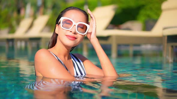 Young asian woman enjoy around outdoor swimming pool for leisure