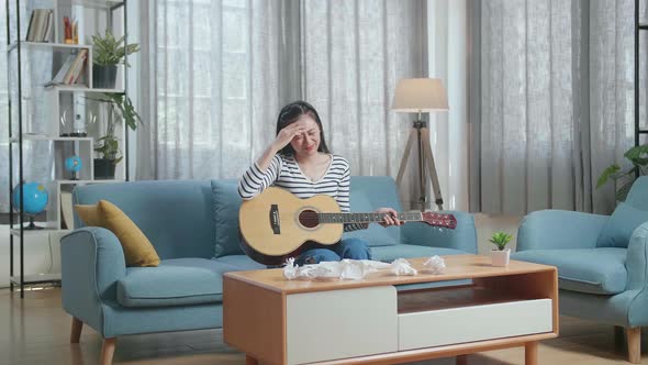 Woman Composer With A Guitar Crumpled Paper And Throw It Away Then Having A Headache While Composing
