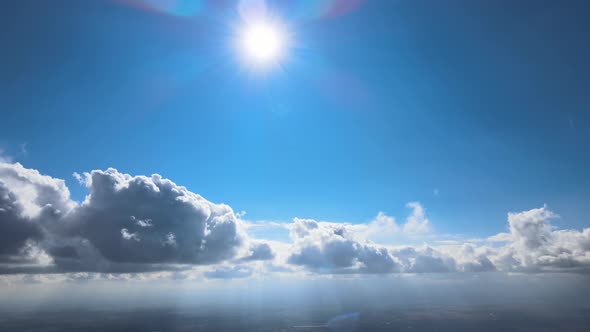 Aerial View From Airplane Window at High Altitude of Earth Covered with White Puffy Cumulus Clouds